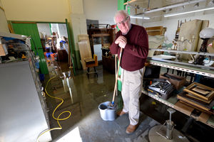 Old Mill Antique Centre owner John Ridgway cleaning up in the aftermath of the floods