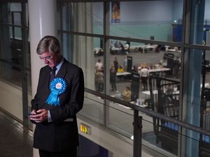 Sir Jacob Rees-Mogg looks at his phone