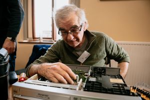 Malcolm Dixon repairing a VHS/DVD player at the first Ludlow Repair Cafe of the decade