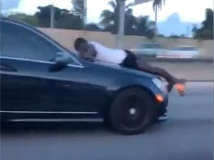 Supporting image for story: Watch: Man clings to front of ex-girlfriend’s car driving at 70mph