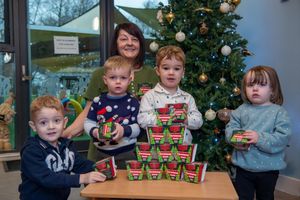 Michelle Lindley with the children at Sandytots Nursery with the donated Christmas tree kits