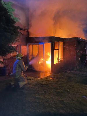 A firefighter attacks the fire in the conservatory. Photo: Market Drayton Fire Station