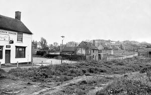 The Kates Hill area of Dudley in May 1969. The story begins: 'A Dudley trader is calling for a meeting to be arranged by the local council to explain redevelopment proposals for what he fears might become a 'ghost town.' He is sub-postmaster Mr W G Smallwood of Tansley Hill Road, Dudley, who has had a shop in St John's Road, Kates Hill, for 23 years. So far, he says, local traders have been neglected in that there has been no official information for them on the future of the area. Mr Smallwood, whose shop is one of five along that stretch of St John's Road, said that with demolition going on in the area it was 'more than an eyesore.' There was no sign of a start to redevelopment and he would like to have a meeting of all interested parties so that they could make their voices heard...' The pub on the left is the Green Dragon, a Joule's pub. According to a history website it was at 7 St John's Street (note discrepancy, story gives the name as St John's Road).