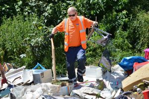 Workers clear up the the pile of rubbish 