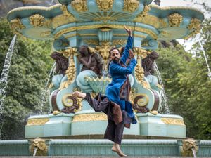 Man dancing in front of a fountain