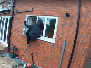 One of the crooks climbs into the window