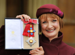 Dame Tessa Jowell proudly holding her Dame Commander insignia, after it was presented to her by the Prince of Wales in 2013