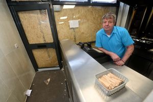 Kikis Minas is pictured with the damage. He was in the shop when the crash happened