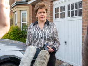 Nicola Sturgeon speaking to the media outside a house