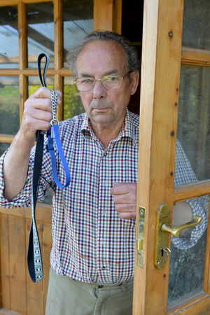 Ken Hackett with Ellie's leash outside the dog's kennel where thieves forced the door