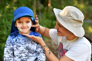 Mille McGarrick puts sun block on her son Jack age four at the Wildlings outdoor schoo
