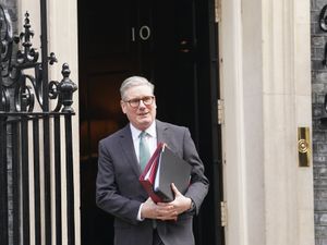 Prime Minister Sir Keir Starmer in front of 10 Downing Street holding two folders