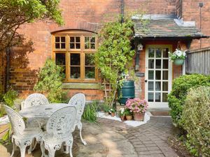 Approaching the house, the gated frontage has an enchanting garden with attractive flowers and plants, and a seating patio near to the front door. Photo: Yopa