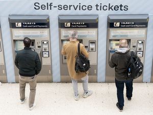 People use a ticket machine at Waterloo train station in London