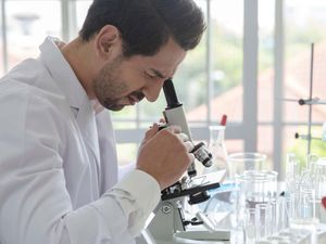 A scientist in a lab doing a microscope analysis