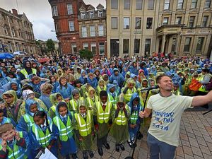Supporting image for story: Wolverhampton school pupils singing in the rain in Queens Square