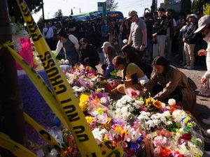 Visitors pay their respects at a memorial to the victims of the car ramming attack in Vancouver