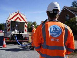 Worker in orange jacket sporting a Thames Water logo on the back