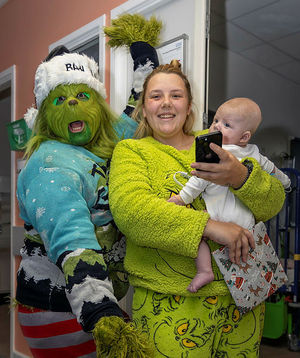 The Grinch with mum Gemma Eccles holding her baby son Cooper