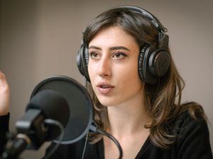 Cecilia Sala wearing headphones and speaking into a microphone