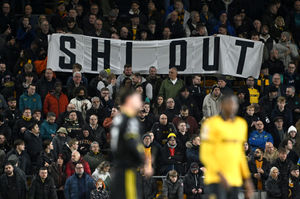 Wolves fans hold up a protest banner reading "Shi Out" during the Premier League match against Manchester United at Molineux on Monday