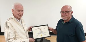 Roger, on the left, being presented with a framed award by the choir chairman, Chris Forde.