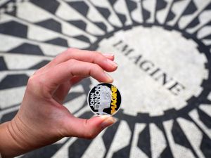 John Lennon coin being held