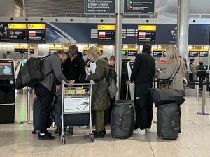 Passengers queue at a check-in desk at Heathrow Terminal 2