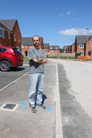 Charlie Brayson standing on unfinished pavment on Buckthorn Drive at Hollington Grange estate in Stoke-on-Trent.