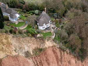 Supporting image for story: Cottage left teetering on cliff edge following massive landslip