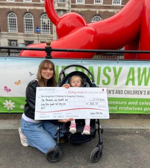 Lauren and Ellarae presenting some of their fundraising at Birmingham Children's Hospital