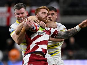 Wigan Warriors Adam Keighran is tackled by Warrington Wolves Lachlan Fitzgibbon, left