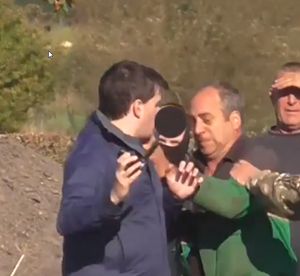 The farmer attempts to snatch one of the saboteurs' phones