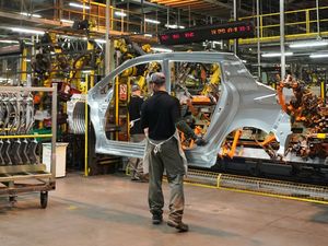 Workers on a production line at a car factory