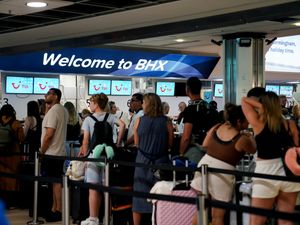 Passengers queue at Birmingham Airport