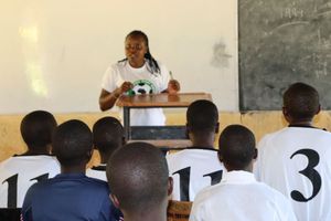 A volunteer teaching boys and girls about gender-based violence. 