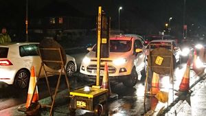 Cars pass through as temporary traffic lights are in place for roadworks