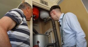 Kenneth Smith (Left) looking at heat pump cylinder in his Dudley home. PIC: WMCA