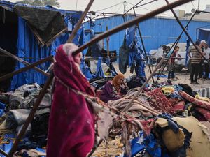 Palestinians inspect the damage caused by an Israeli airstrike that struck tents at Al-Aqsa Hospital in Deir al-Balah