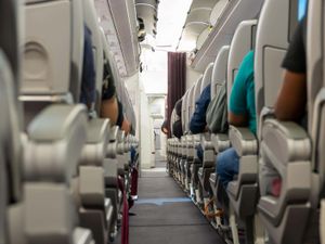 Interior of an airplane with passengers sitting on seats