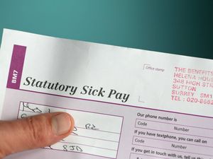 A hand holding a statutory sick pay form