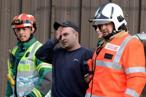 Tomasz Wiszniewski is led from the warehouse after being rescued
