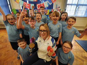 Supporting image for story: Athlete shows off her medals to pupils