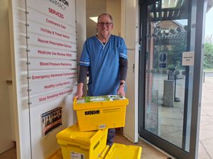 Conservative councillor Nigel Dugmore at the Donnington Pharmacy with a pile of four boxes of uncollected prescribed drugs.