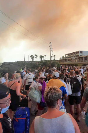 Tourists being evacuated during a forest fire on the island of Rhodes on Saturday. Photo: Rhodes.Rodos via AP.