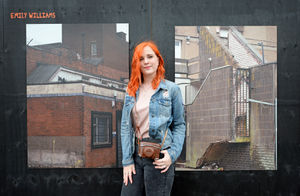 Student Emily Williams next to some of her photographs which feature in the exhibition