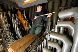 Organ builder Ashley Tooze examines one of the pipes