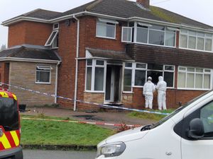 Investigators examine a broken window