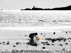 Silhouette of child playing alone on a beach