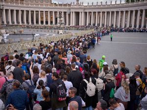 People stand in line as they wait to enter St Peter’s Basilica